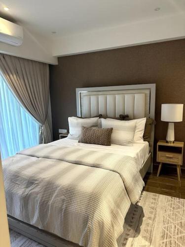 阿克拉Luxurious Apartment的卧室配有一张大白色床和窗户
