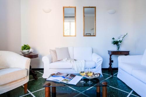圣玛格丽塔-利古雷Daisy by PortofinoHomes的客厅配有2张白色沙发和1张桌子