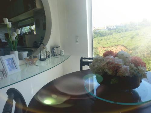 沃尔塔雷东达Pousada Flor de Lis Homestay的花瓶上的玻璃桌