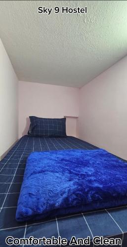 迪拜SKY 9 Hostel ,UNION METRO的卧室配有蓝色毯子,位于床上
