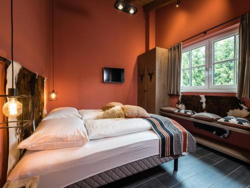 莱奥冈Chalet Schneelöwe L的一间卧室配有一张带橙色墙壁的大床