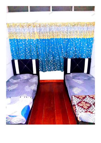 怡保AABM DELIMA HOMESTAY的两张睡床彼此相邻,位于一个房间里