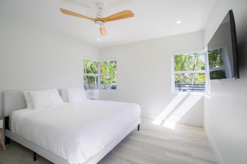 迈阿密Havana House Miami的白色卧室配有床和吊扇