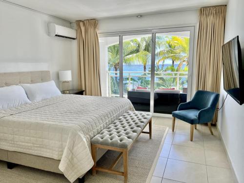 马霍礁Maho Beach Suite 2BR Lux Condo next to Morgan Resort的卧室配有床、椅子和窗户。