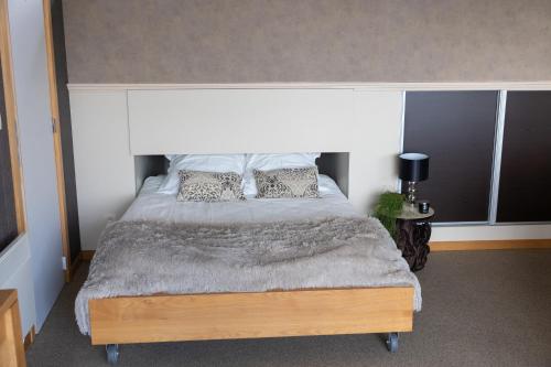 雅莱Le Petit Logis的一间卧室配有一张大床和枕头