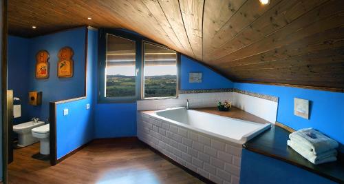 穆里略德加列戈Hotel rural reina Berta的蓝色的浴室设有大浴缸和卫生间