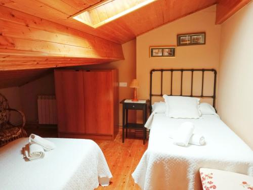 Poo de CabralesCasa Pelayo 2的一间卧室设有两张床和木制天花板
