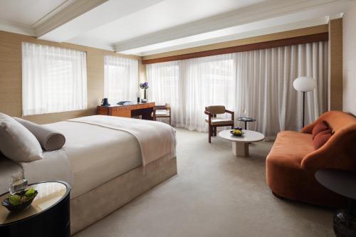 纽约The Prince Kitano New York的酒店客房设有一张大床和一张沙发。