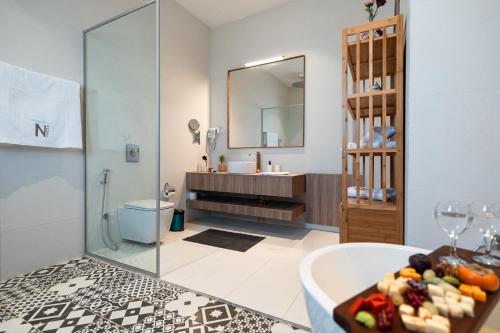 安曼Nammos Experience的带浴缸、水槽和镜子的浴室