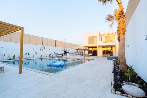 安曼Nammos Experience的棕榈树建筑旁边的游泳池