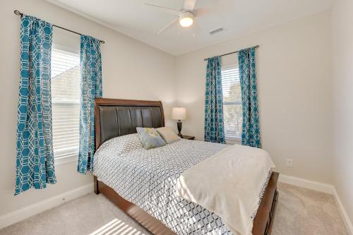 威尔明顿Pet-Friendly Wilmington Home - 2 Mi to Riverwalk的一间卧室配有床和2个带蓝色窗帘的窗户。
