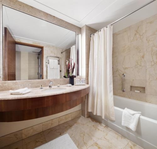 纽约The Prince Kitano New York的一间带大镜子、浴缸和水槽的浴室
