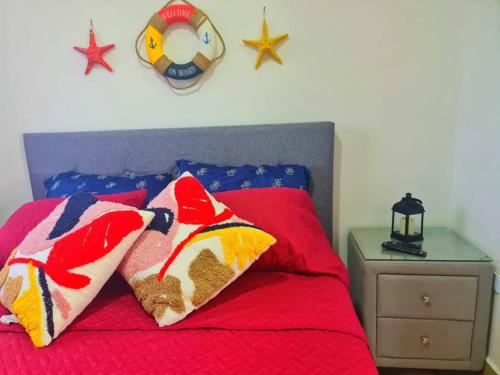 Palo GrandeFront Beach apartment的一间卧室配有红色的床和两个枕头