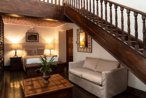 迪坡斯特兰Posada del Tepozteco - Hotel & Gallery的一间带床和楼梯的客厅