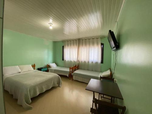 帕苏丰杜Pousada355的一间卧室配有一张床、一张沙发和一台电视