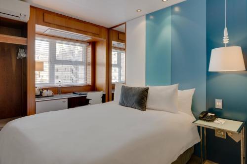 开普敦普罗蒂亚万豪酒店 - 开普敦海点店的卧室配有白色的床和蓝色的墙壁