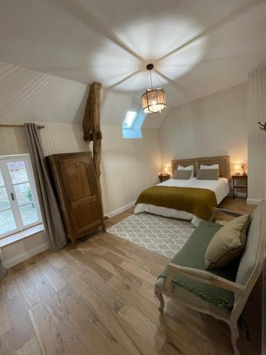 Ully-Saint-GeorgesGîte du fournil « Chez Nicole »的一间卧室配有一张床和一张沙发