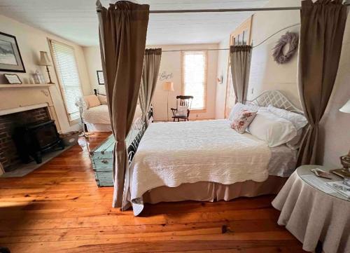 赛维尔维尔Historic Seaton Springs Farm B&B - James Tipton En-Suite Triple Room的一间卧室设有一张大床和一个壁炉