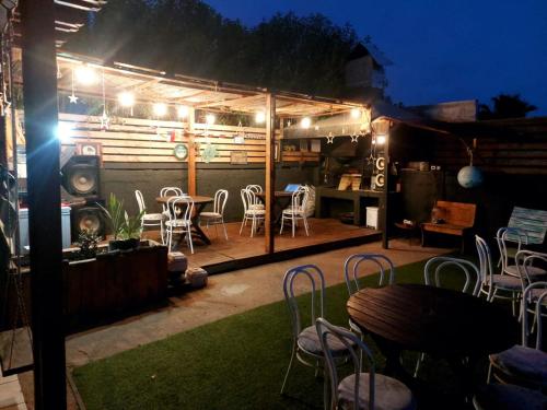 科金博Coco Cris Hostal的庭院配有桌椅和夜间照明灯。