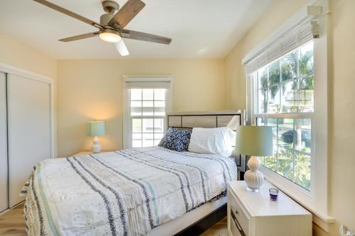 亨廷顿海滩Huntington Beach Hideaway Near Beach and Downtown!的一间卧室配有一张带吊扇和窗户的床。