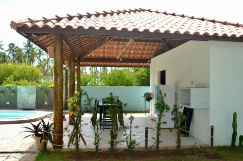 佩德拉斯港Vila Las Hermanas的庭院设有木制凉亭,毗邻游泳池