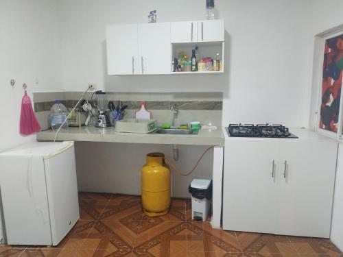 曼塔Mini Suite的厨房配有白色橱柜和黄色垃圾桶