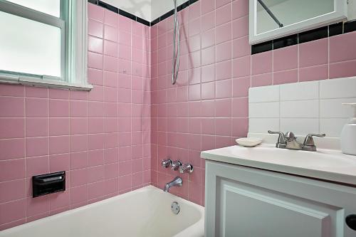 沃思湖Steps to Beach & Downtown! Cozy Beach Bungalow #4的粉红色的浴室设有浴缸和水槽