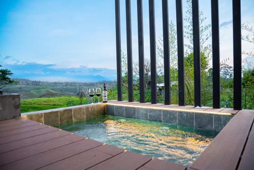 菲兰迪亚Ecohotel Monte Tierra Habitaciones y Glamping的一个带围栏的游泳池和一瓶葡萄酒