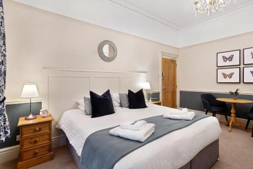 哈罗盖特Fountains Guest House - Harrogate Stays的一间卧室配有一张大床和两条毛巾