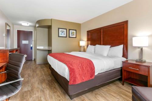 Van BurenComfort Inn and Suites Van Buren - Fort Smith的酒店客房带一张大床和一把椅子