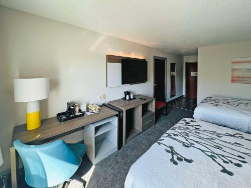 恩波里亚Comfort Inn Emporia的酒店客房配有一张床和一张书桌及一台电视