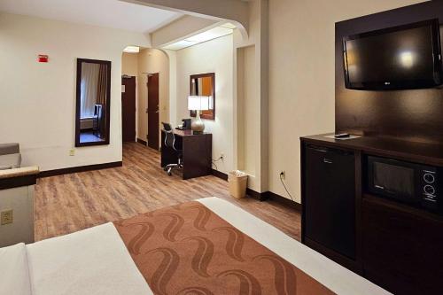 CahokiaQuality Inn & Suites near St Louis and I-255的配有一张床和一台平面电视的酒店客房