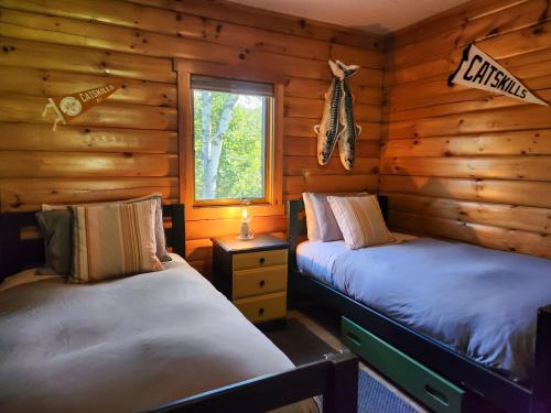 派恩希尔Belleayre Lodge的小木屋内的两张床,设有窗户
