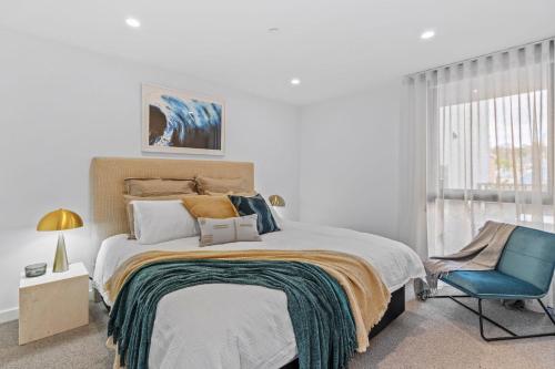霍巴特Designer Apartment - giant terrace - city location的一间卧室配有一张床和一张蓝色椅子