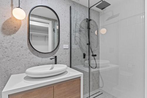 霍巴特Designer Apartment - giant terrace - city location的浴室配有盥洗盆和带镜子的淋浴