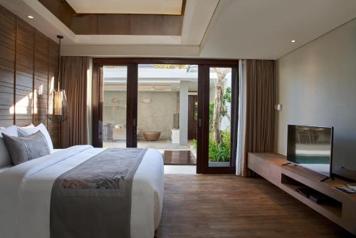 乌鲁瓦图Villa La Casa 2 BR的一间卧室配有一张床、一台电视和一间浴室。