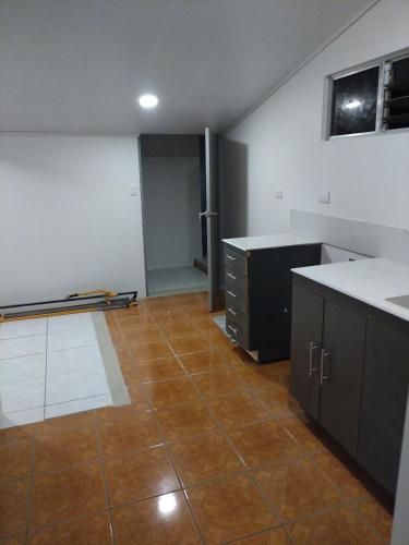 ArenillaCONAB的一间空厨房,铺有瓷砖地板,配有橱柜