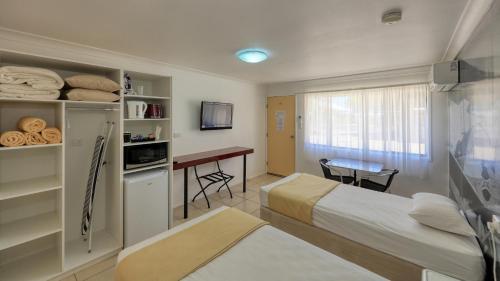 查尔维尔Hotel Corones的配有床和书桌的酒店客房