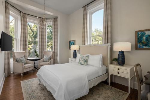萨凡纳汉密尔顿-特纳酒店的白色卧室配有床和桌椅