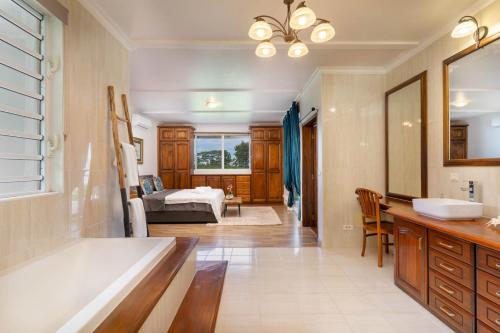 帕皮提la villa Mareva的带浴缸的浴室和1间带1张床的卧室