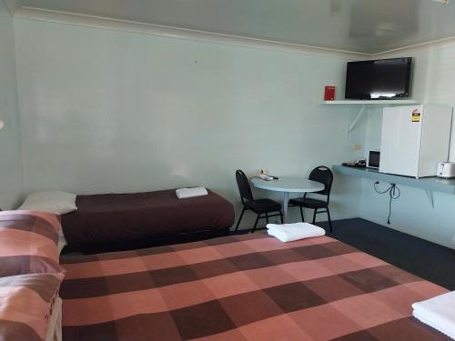 布莱克尔Motel Blackall的客房设有一张床和一张桌子及椅子