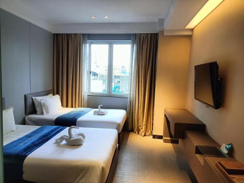 马尼拉pristine848的酒店客房设有两张床和电视。