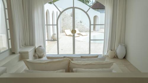 坎古MAJA Canggu的客厅配有白色家具和大窗户