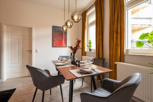 格拉maremar - Design Apartment - Luxus Boxspringbett - Zentral - Arbeitsplatz - Highspeed WLAN的一间带桌椅的用餐室