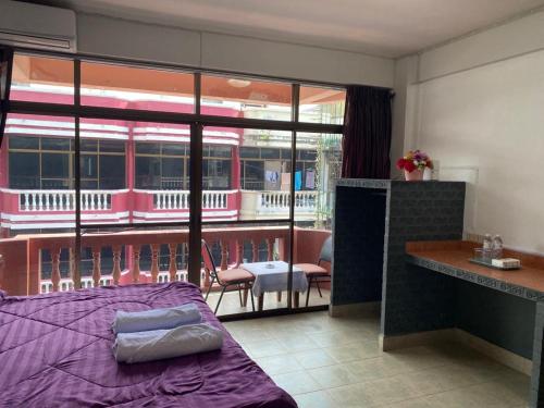 乔木提恩海滩Chai Ben guesthouse的一间带紫色床的卧室和一个阳台