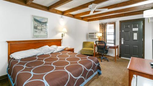乔治城Georgetown Lodge的一间卧室配有一张床、一张桌子和一把椅子