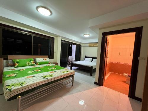 芭东海滩Hideaway House Patong的一间卧室配有一张带绿色床单的大床