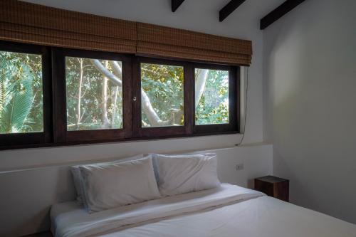 涛岛Lunar Villas Koh Tao - Luxury Private Pool Villas的窗户间内的一张带两个枕头的床