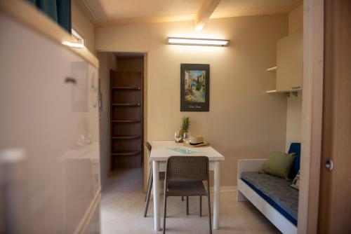 切齐纳码头Campeggio Bocca di Cecina的小房间设有桌子和床