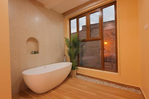 尼兹瓦House 76的一间带白色浴缸和窗户的浴室